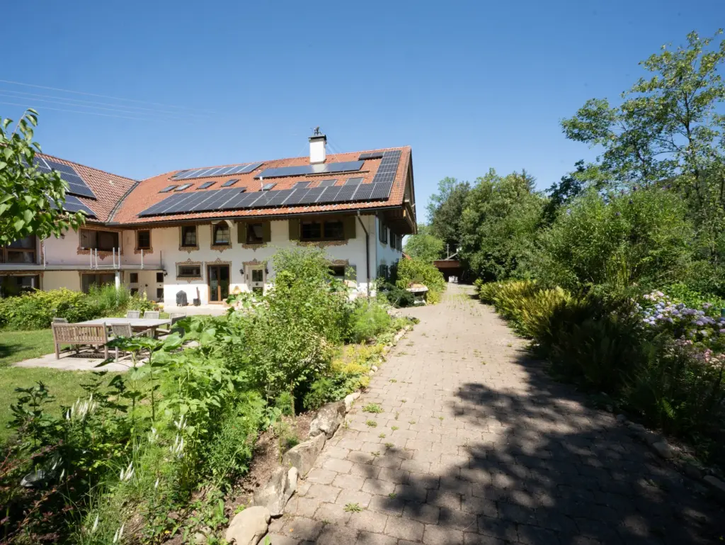 Weg am Haus entlang durch den blühenden Garten