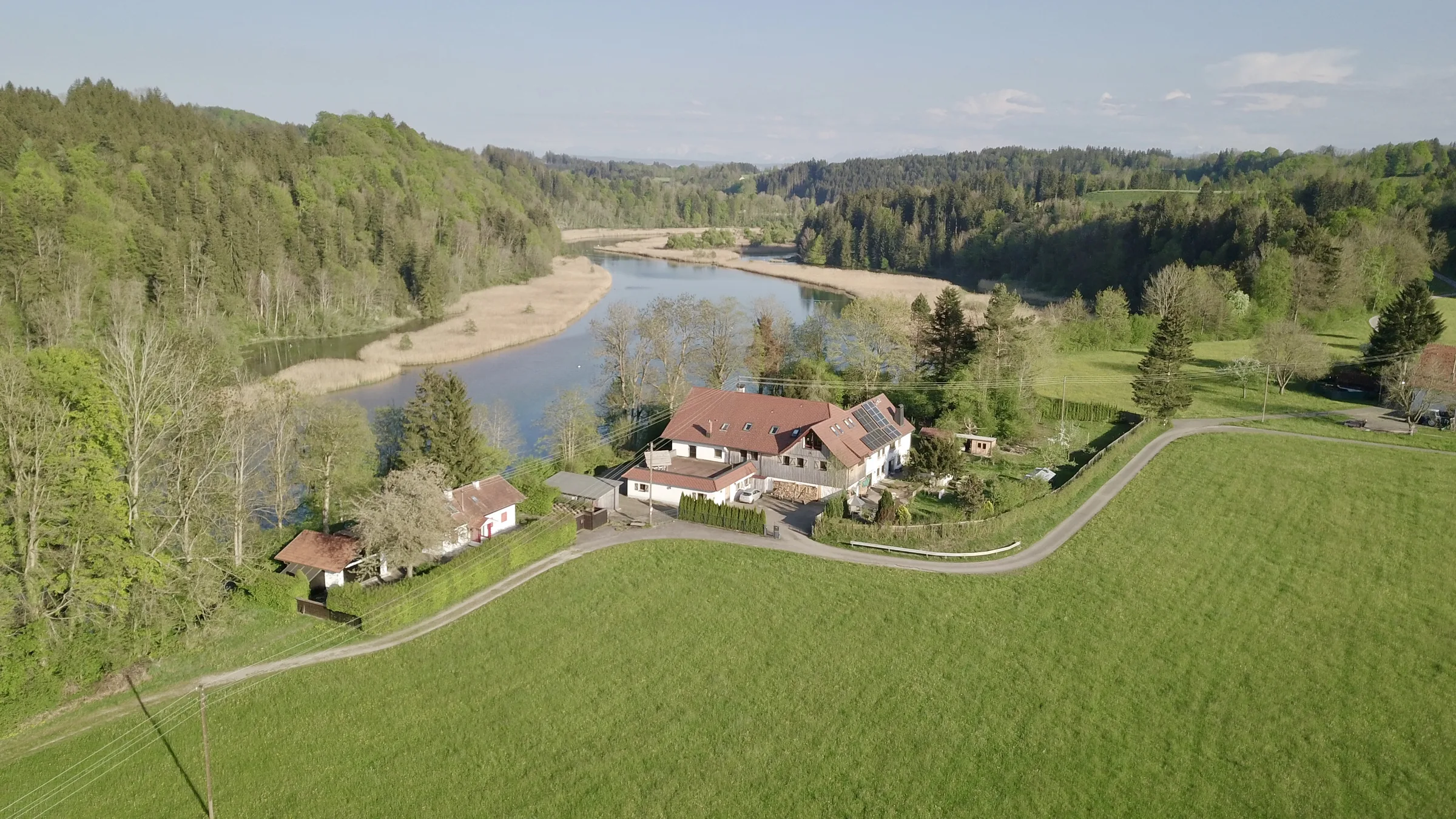 Das Haus an der Iller im Frühling, Luftaufnahme mit Fluss, Wald und Wiesen