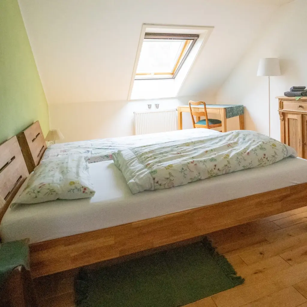 Doppelzimmer mit Holzbett und Dachfenster