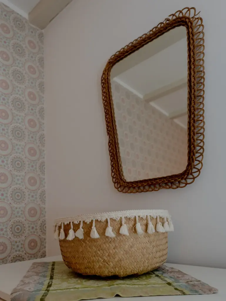 Zimmer 2: Rattanspiegel und Korb auf einer Kommode