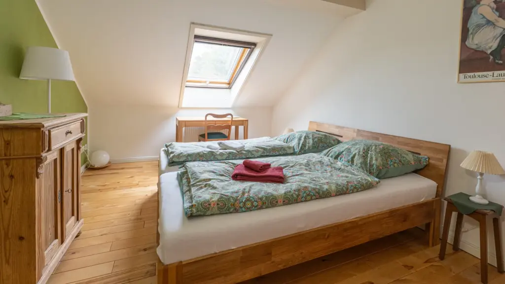 Zimmer 5: Dachfenster, grüne Wand und Kommode aus Holz