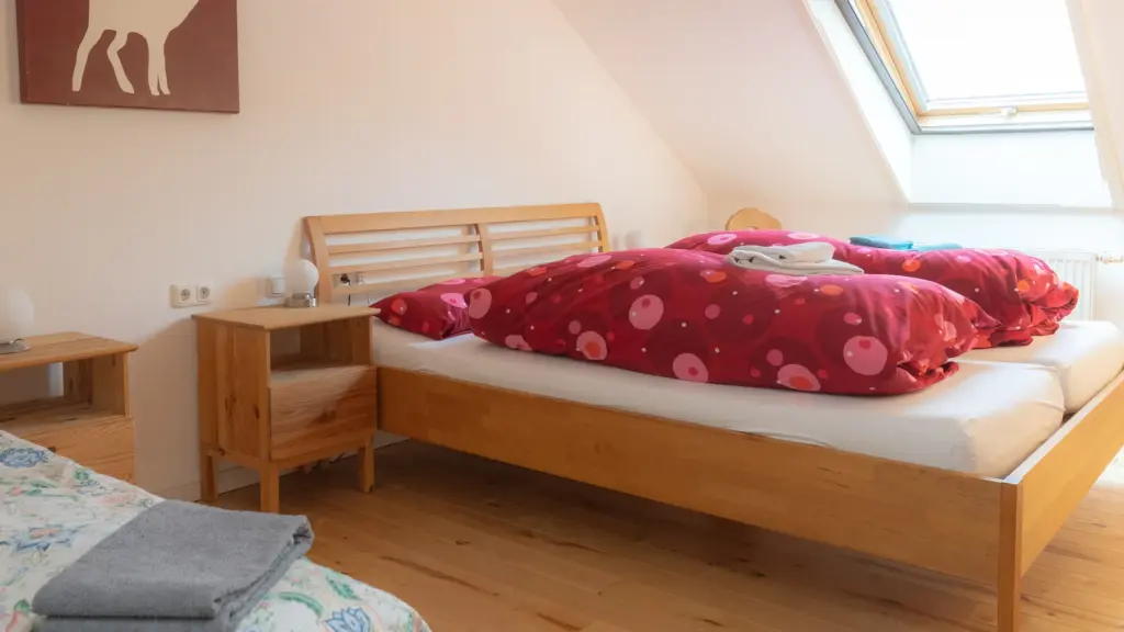 Zimmer 6: Bett mit Nachttisch, an der Wand ein Hirsch-Motiv