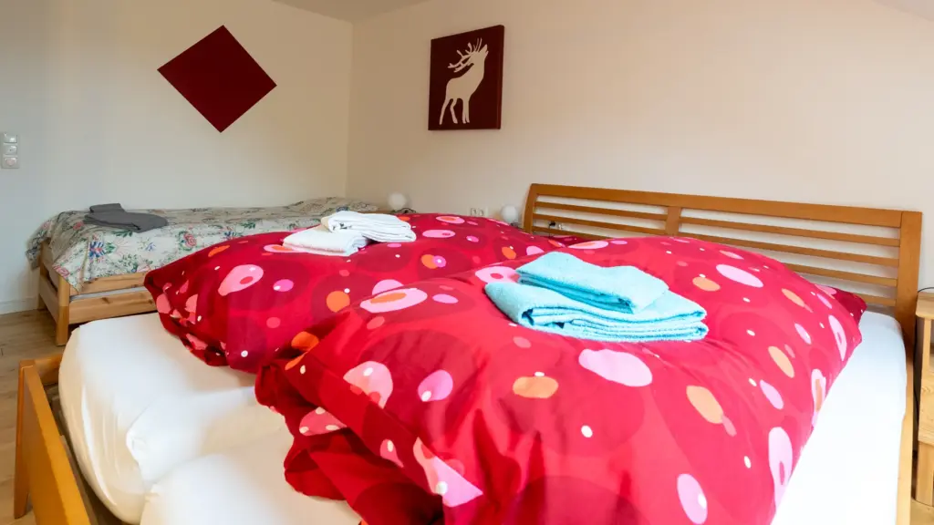 Zimmer 6: Doppelbett und ein weiteres Einzelbett im Dachgeschoss